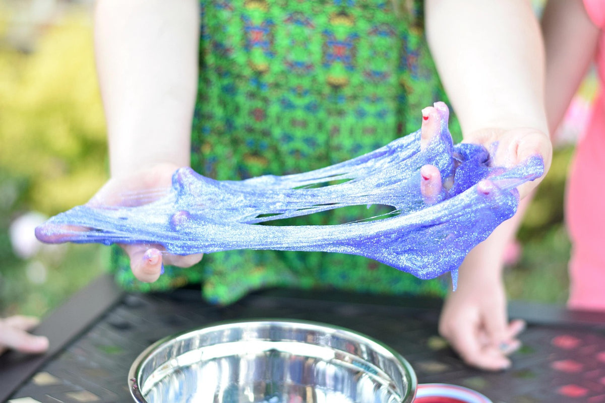 Illustrative glitter slime being stretched by hand; not a photo of the Do Dough kit